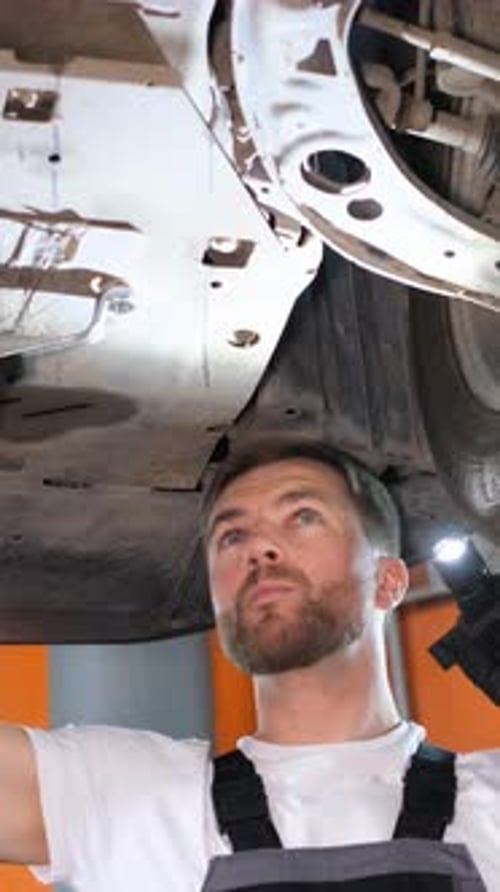 A Highly Skilled Mechanic is Meticulously Performing Essential Maintenance Work on a Vehicle Within
