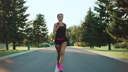 Sport woman running outdoor training in morning park slow motion exercise