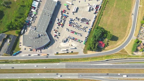 Aerial view of the logistics park with warehouse, loading hub and many semi trucks with cargo traile