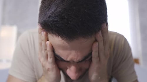 Distraught Young Adult with Hands on Face