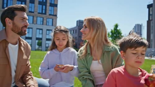 Happy Family Having Picnic on Green Grass Sunny Day Closeup Children Eating
