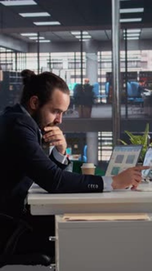 Bearded Man Working on Laptop in Modern Office