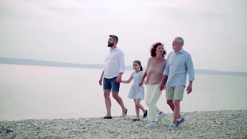 A Multigeneration Family on a Holiday Walking by the Lake, Holding Hands
