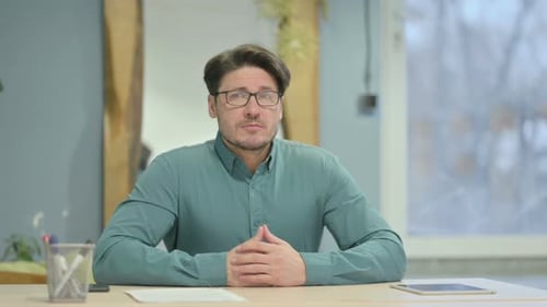 Pensive Mature Adult Man Thinking while Sitting at Work