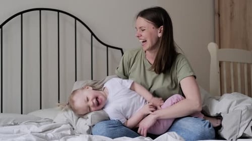 Loving Mother and Child Playing on Bed