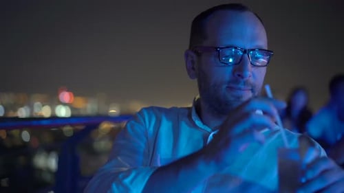 Young, Happy Man Drinking Cocktail Sitting on Terrace in Bar at Night Alcohol