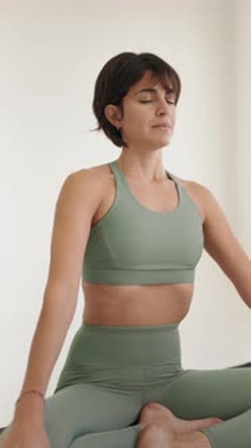 Woman Meditating in Yoga Pose in Bright Room