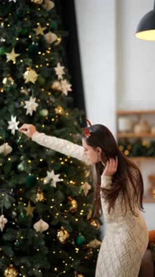Girl Decorating Christmas Tree at Home