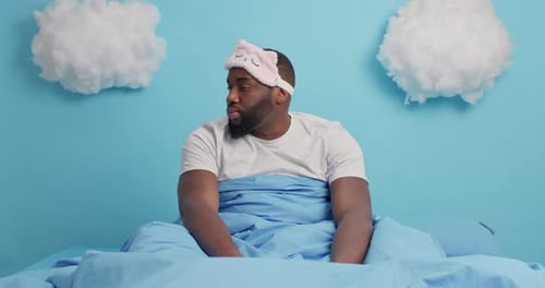 Man Waking Up and Stretching in Bed