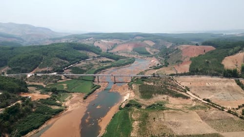 Drone at High Altitude Flies Over the Mountains the Bridge and the Large River with Little Flow in