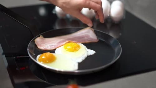 Frying Up Some Delicious Eggs Along with Bacon in a Pan for a Perfect Breakfast Dish