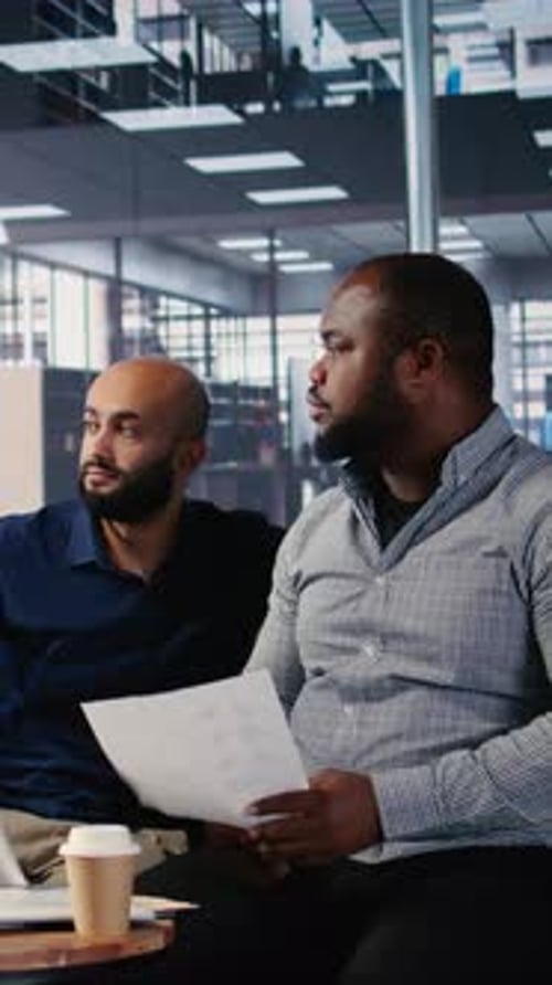 Dispute de groupe vidéo vertical dans le siège d'une Entreprise entre des professionnels de divers horizons