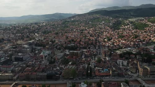 Drone view of the Bosnian city built at the foot of the mountain, view of trees between buildings