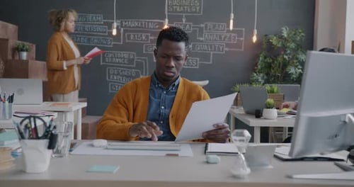 Zoomin Portrait of African American Businessman Working with Computer Typing at Desk in Office
