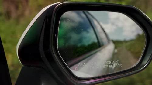 View of the road on the side mirror of a moving car