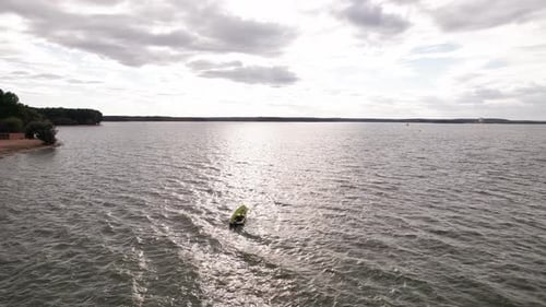 Man is Sailing in Motor Boat on Waves and Panorama of Bay with Sailboats on Horizon From Bird's Eye