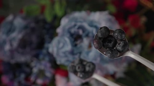 Blueberries Falling From Spoon on Floral Background