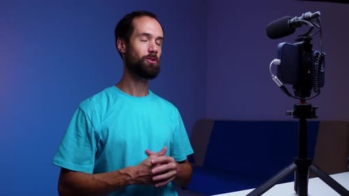 Un joven bloguero graba un vídeo consigo mismo en su teléfono en su estudio