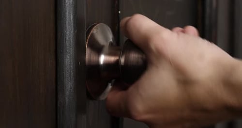 Hand Turns Bronze Door Knob Close Up