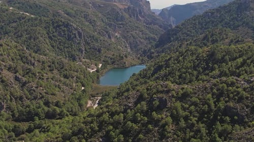 High mountain reservoir. Aerial view and approach to dam and lagoon in a mountainous Mediterranean v