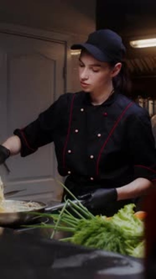 Young Adult Chef Cooking Food in Professional Kitchen