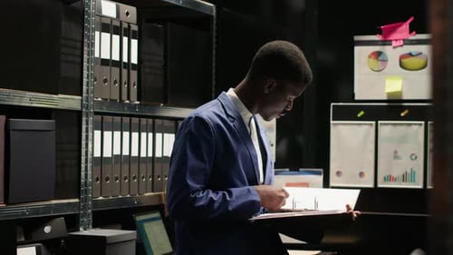 Man Working in Storage Room with Documents