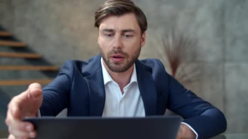 Junger Geschäftsmann schließt Laptop nach einem Arbeitstag im Remote-Büro
