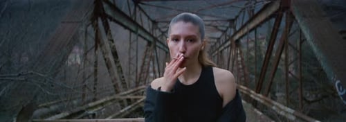Sexy Girl Smokes Fashion Portrait of a Female Young Woman on an Old Bridge with a Cigarette
