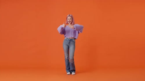 Enthusiastic Woman Demonstrating Thumbs Up Gesture in Studio