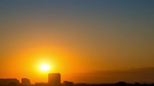 Sunrise in a Clear Sky over City Rooftops