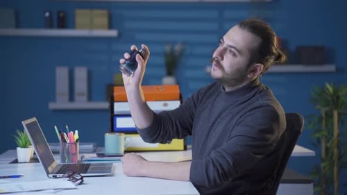 Man Sprays Cologne at Desk in Home Office