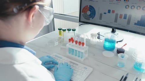 Adult Typing at Lab Table with Beakers