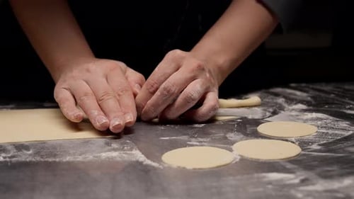 Woman Shaping Dough with Cookie Cutter in Kitchen