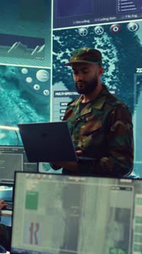 Man Using Laptop in Futuristic Command Center