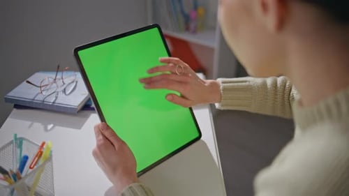 Woman Interacts with Tablet with Chroma Key Screen