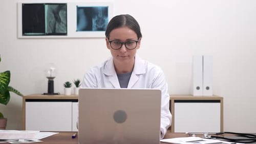 Young Female Doctor Reviews Examination of Patient Organs on Laptop Working in Modern Clinic