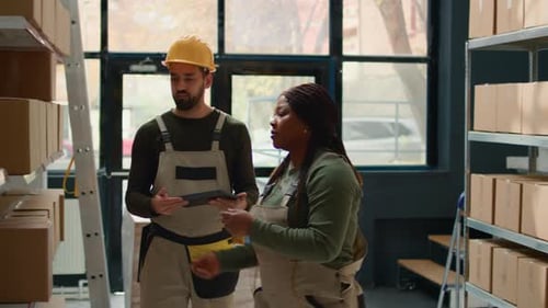 Warehouse Employees Coordinating Stock with Tablet and Phone