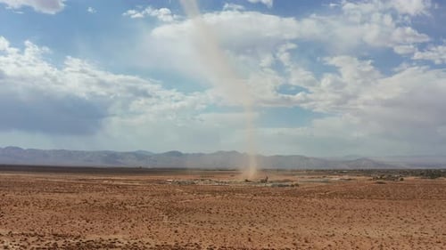 A sandstorm or dust devil with spinning wind send a dust cloud in the sky like a small tornado - aer