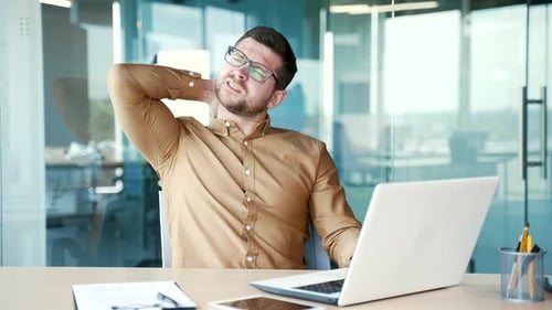 Man Experiences Neck Pain at Office Desk