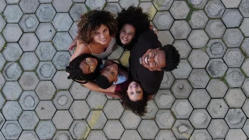 Black family hugging each other in circle together looking up