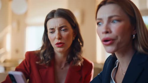 Business Women Viewing Phone At Table Indoors