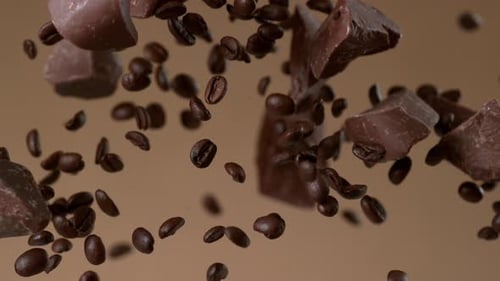 Chocolate chunks and coffee beans falling in slow motion