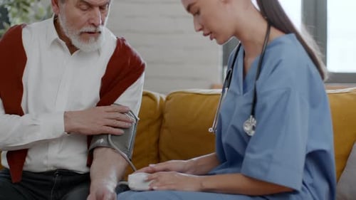 Senior Man Getting Blood Pressure Checked by Healthcare Worker