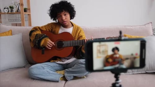 Young Adult Playing Acoustic Guitar at Home