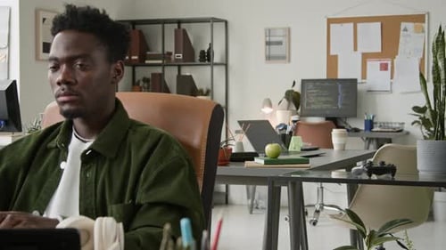 Deux programmeurs multiethniques, hommes et femmes, travaillant dans un bureau partagé