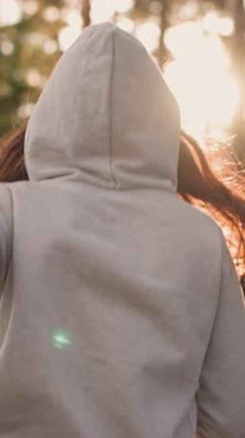 Woman in Hood Jogging in Forest