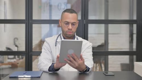 Mixed Race Doctor Using Tablet in Clinic