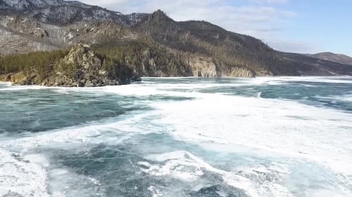 A Stunning Winter Landscape Featuring a Beautifully Frozen Lake Surrounded By Majestic Mountains
