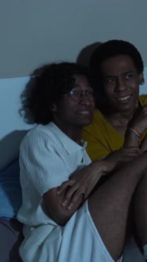 Friends Laughing Together on a Bed at Night