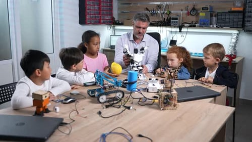 Enthusiastic Male Teacher Showing a Robot Android f